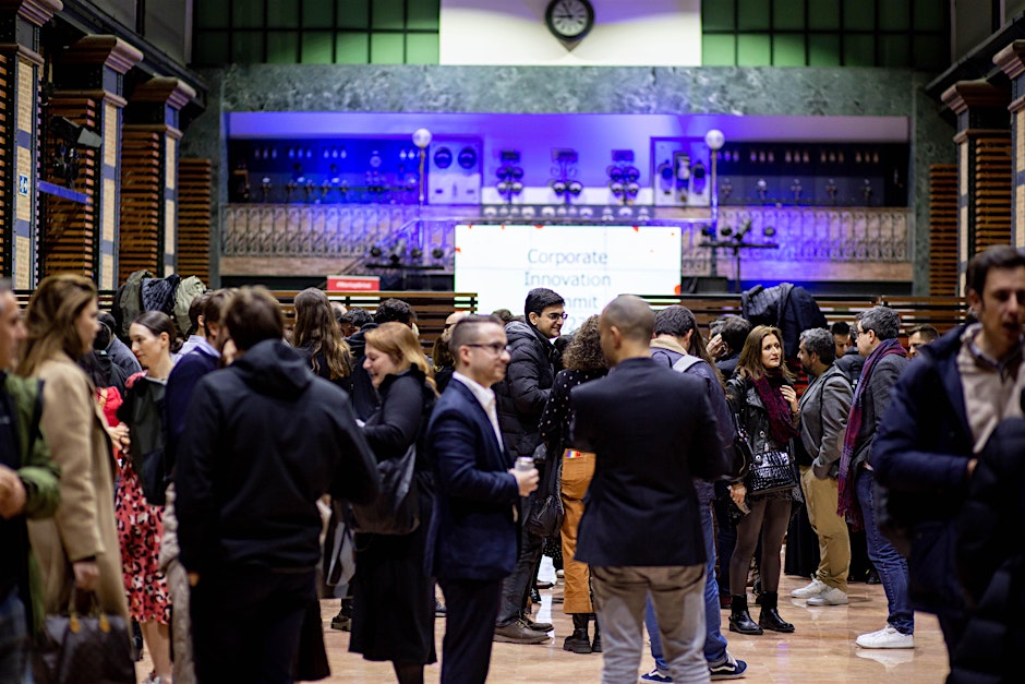 Featured event: Attendees networking at the Corporate Innovation Summit 2025, held in a vibrant venue with a historic and industrial interior design